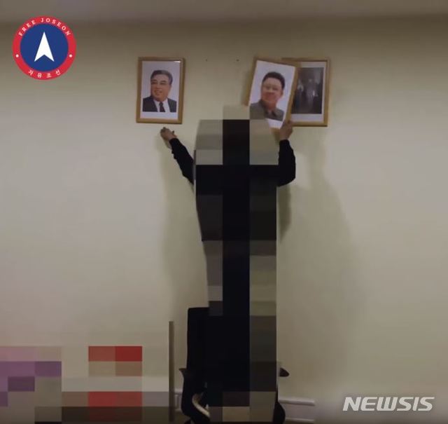 【서울=뉴시스】말레이사아 쿠알라룸푸르 주재 북한 대사관 외벽 낙서 테러를 감행한 것으로 알려진 '자유조선'(옛 천리마민방위)이 김일성·김정일 초상화를 훼손하는 영상을 올렸다. 자유조선은 지난 20일 홈페이지에 이같은 영상을 올리고 "김일성 김정일 김정은 신격화를 타도한다. 조국을 위해 우리는 일어난다. 자유조선 만세! 만세! 만세!"라고 글을 썼다. 2019.03.21. (사진=자유조선 유투브 채널 캡쳐) photo@newsis.com