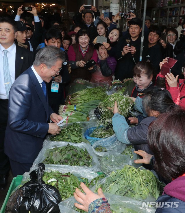 【대구=뉴시스】박진희 기자 = 문재인 대통령이 22일 대구시 북구 칠성종합시장에서 물건을 구입하며 상인들과 대화를 하고 있다.&nbsp; 2019.03.22.&nbsp; pak7130@newsis.com