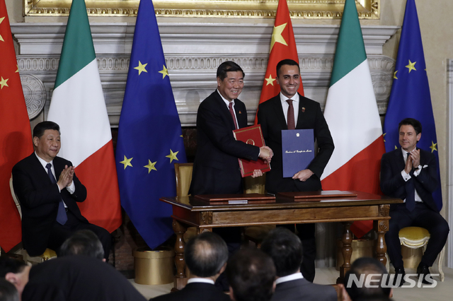 【로마=AP/뉴시스】23일(현지시간) 이탈리아의 로마 영빈관(빌라 마다마) 루이지 디 마이오 이탈리아 부총리(왼쪽 세번째)과 허리펑 중국 국가발전개혁위원회 주임(왼쪽 두번째)이 양국을 대표해 일대일로 양해각서(MOU)에 서명하고 악수하고 있다. 양측에는 주세페 콘테 이탈리아 총리와 시진핑(習近平) 중국 국가주석이 박수를 치고 있다. 이로써 이탈리아는 일대일로에 참여한 첫번째 국가가 됐다. 2019.03.23 