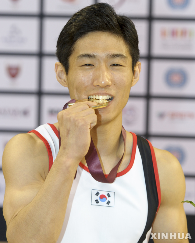 【도하(카타르)=신화/뉴시스】양학선이 23일(현지시간) 카타르 도하에서 열린 제12회 국제체조연맹(FIG) 기계체조 월드컵 도마 종목에서 우승, 시상대에 올라 금메달을 깨물며 포즈를 취하고 있다. 양학선은 1-2차 시기 평균 15.266점으로 우크라이나의 이고르 라디빌로프(14.916점)를 따돌리고 우승했다. 3위는 아르메니아의 아르투르 다브티얀 (14.695점). 2019.03.24.