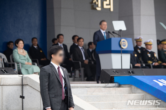 【서울=뉴시스】전신 기자 = 지난 22일 문재인 대통령의 대구 칠성시장 방문 당시 경호원이 기관단총을 들고 경호하는 모습이 찍힌 사진이 뒤늦게 알려지면서 '과잉 경호' 논란이 일고 있는 가운데 청와대는 이에 즉각 "경호원이 대통령과 시민들을 지키고자 무기를 지닌 채 경호 활동을 하는 것은 지극히 당연한 직무수행"이라고 반박하며 그간 대통령의 외부 행사에서 청와대 경호처 직원들이 총기를 들고 대통령을 경호하고 있는 사진 여러 장을 공개했다. 2019년 해사 졸업 및 임관식 당시의 경호 모습. 2019.03.24. (사진=청와대 제공) photo@newsis.com