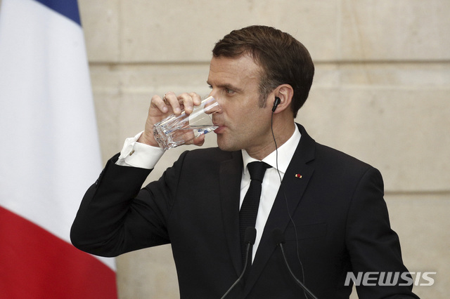 【파리=AP/뉴시스】 에마뉘엘 마크롱 프랑스 행정부가 향후 3년간 12만명의 공무원을 감축하는 공공부문 개혁안에 착수했다고 27일(현지시간) 파이낸셜타임스가 보도했다. 현재 프랑스 중앙·지방정부, 정부 산하기관에서 일하는 공무원은 550만명에 달한다. 사진은 25일 파리 엘리제궁에서 열린 시진핑 중국 국가주석과의 공동기자회견에서 물을 마시고 있는 마크롱 대통령. 2019.03.27.