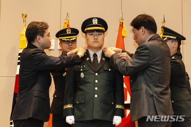 【영동=뉴시스】이성기 기자 = 29열린 육군종합행정학교 91기 법무사관 임관식에서 신임 박정화 대위에게 이남우 국방부 인사복지실장(왼쪽)과 박 대위의 아버지가 계급장을 달아주고 있다.2019.03.29.(사진=육군종합행정학교 제공)photo@newsis.com