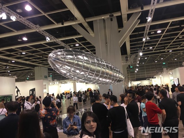 【홍콩=뉴시스】 박현주 미술전문기자 = 홍콩 아트바젤은 은빛 대형 비행선 'To Be Vulnerable'(취약할 의향)을 올려다보는 것으로 시작된다. 1층 전시장에 들어서자마자 볼 수 있게 설치된 이 작품은 이불 작가가 1937년 5월 힌덴부르크 비행선 폭발로 승객 35명이 사망한 사건을 소재로 한 작품으로길이 12m의 비행선 밑에 벌집 모양의 반사판이 깔려 있다. 수많은 관람객과 멀미가 날 정도로 쏟아진 그림들 속에 아트바젤 이정표 같은 작품으로 인기를 끌었다.