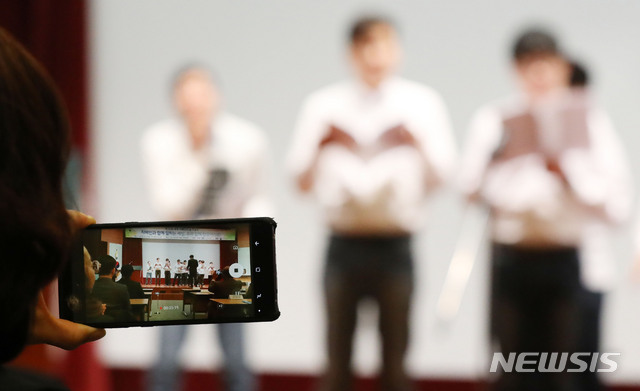 【서울=뉴시스】박미소 수습기자 = 2일 오전 서울 중구 포스트타워에서 열린 '세계 자폐인의 날 기념식'에서 한 참석자가 씽씽합창단의 공연을 스마트폰으로 기록하고 있다. 씽씽합창단은 발달장애인으로 구성된 성인합창단이며 한국자폐인사랑협회 소속으로 활동 중이다. 2019.04.02. misocamera@newsis.com