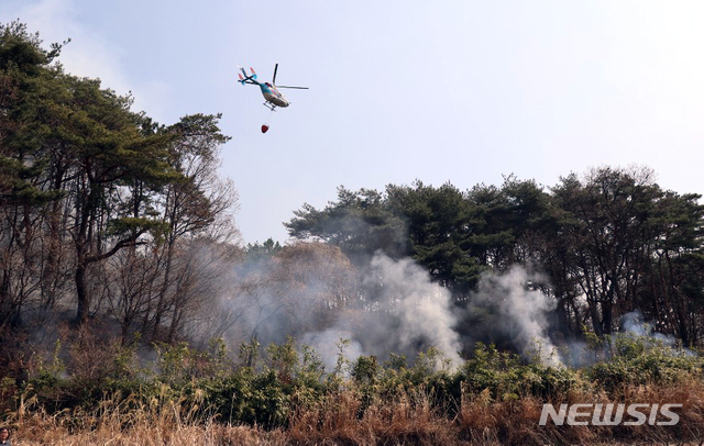 【부산=뉴시스】 지난 3일 오전 부산 해운대구 운봉산 일대 산불 현장에서 이틀 동안 진화작업이 펼쳐지고 있는 가운데 헬기가 물을 뿌리고 있다. 2019.04.03. (사진=부산소방본부 제공) photo@newsis.com