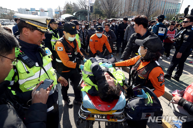 【서울=뉴시스】김병문 수습기자 = 3일 오후 서울 여의도 국회 정문에서 민주노총 주최로 열린 '노동법 개악 저지-노동기본권 쟁취 민주노총 결의대회'에서 다친 경찰이 실려나가고 있다. 2019.04.03.  dadazon@newsis.com