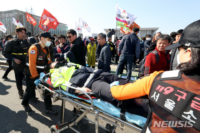 【서울=뉴시스】김병문 수습기자 = 지난 4월3일 오후 서울 여의도 국회 정문에서 민주노총 주최로 열린 '노동법 개악 저지-노동기본권 쟁취 민주노총 결의대회'에서 다친 경찰이 실려나가고 있다. 2019.04.03.  dadazon@newsis.com