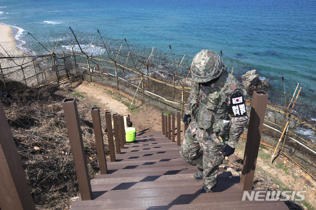 【고성(강원)=뉴시스】김경목 기자 = 오는 27일 휴전 협정 이후 처음으로 민간인의 도보 통행 개방을 앞둔 강원도 고성군 통일전망대 'DMZ(비무장지대) 평화안보 체험길(가칭 평화둘레길)' 조성을 위해 인부가 육군 장병의 경호를 받으며 작업을 하고 있다. 2019.04.03. photo31@newsis.com