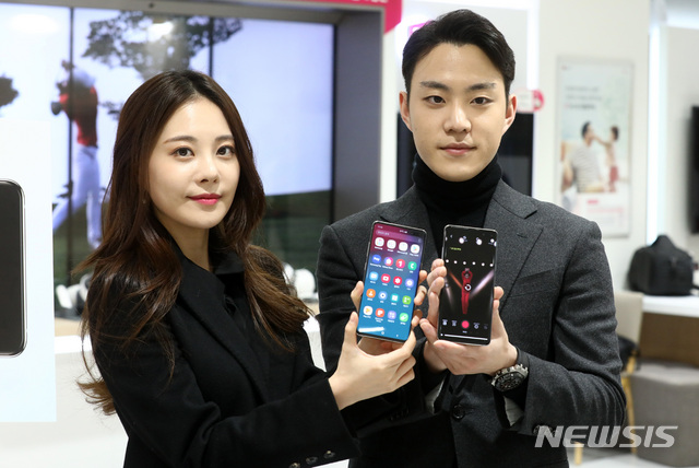 【서울=뉴시스】이영환 기자 = 3일 오후 서울 종로구 LG유플러스 종로직영점에서 LG유플러스 갤럭시 S10 5G 1호 고객인 모델 겸 방송인 김민영씨와 카레이서 서주원씨 부부가 직원에게 갤럭시 S10 5G 휴대폰 개통을 마치고 포즈를 취하고 있다. LG유플러스는 1호 고객에게 갤럭시 S10 5G 단말에 갤럭시 탭 S4를 추가로 제공하고 5G 프리미엄 요금제를 12개월간 무상 지원한다고 밝혔다. 2019.04.04.&nbsp; 20hwan@newsis.com