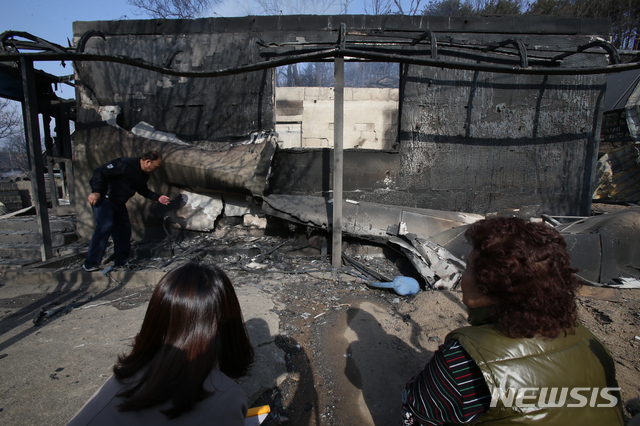 【속초=뉴시스】김경목 기자 = 5일 오전 강원 속초시 장사동 장천마을 주민들이 전날 밤 고성군 토성면 원암리 미시령 관통도로 요금소 인근에서 변압기가 터져 발생한 산불로 잿더미가 된 집을 보며 슬픔에 빠져 있다. 2019.04.05. photo31@newsis.com
