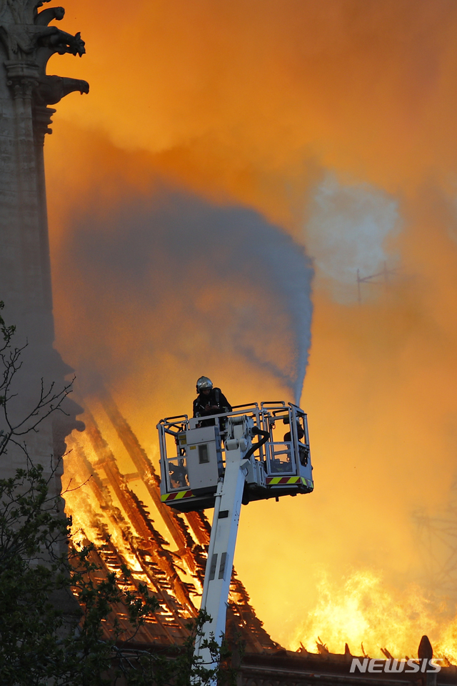 【파리=AP/뉴시스】 프랑스 파리에서 15일(현지시간) 한 소방대원이 노트르담 대성당 불길을 잡기 위해 애쓰고 있다. 2019.04.16 