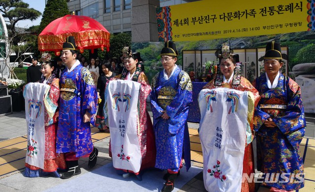 【부산=뉴시스】 하경민 기자 = 16일 부산 부산진구청 앞 마당에서 다문화 부부 3쌍이 합동 전통혼례를 올리고 있는 가운데 내외빈들이 행진하는 부부에게 쌀을 던지고 있다. 2019.04.16.  yulnetphoto@newsis.com