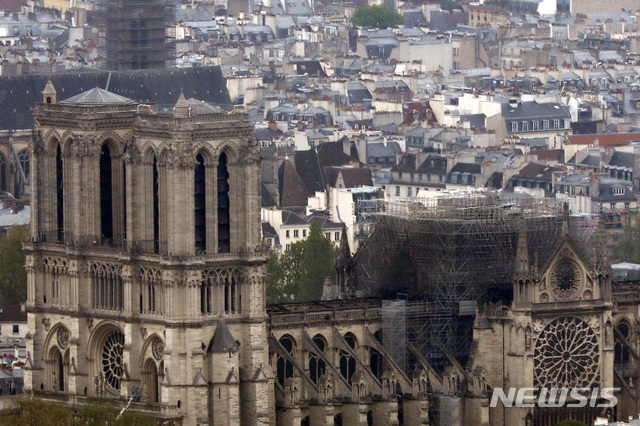 Notre Dame cathedral is pictured from the top of the Montparnasse tower, Tuesday April 16, 2019 in Paris. Firefighters declared success Tuesday morning in an over 12-hour battle to extinguish an inferno engulfing Paris' iconic Notre Dame cathedral that claimed its spire and roof, but spared its bell towers. (AP Photo/Thibault Camus)