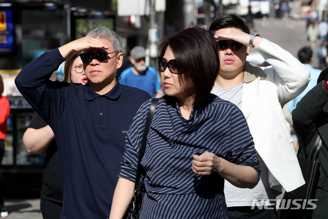 【서울=뉴시스】김병문 수습기자 = 낮 최고기온 23도를 기록하며 초여름 날씨를 보이는 17일 오후 서울 중구 명동에서 썬글라스를 착용한 외국인 관광객들이 손으로 햇빛을 가리고 있다. 2019.04.17. dadazon@newsis.com