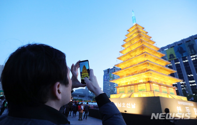 【서울=뉴시스】박미소 수습기자 = 17일 오후 서울 종로구 광화문광장에서 열린 '2019 연등회 광화문 점등식'에서 한 시민이 미륵사지 탑등을 찍고 있다. 2019.04.17.&nbsp; misocamera@newsis.com