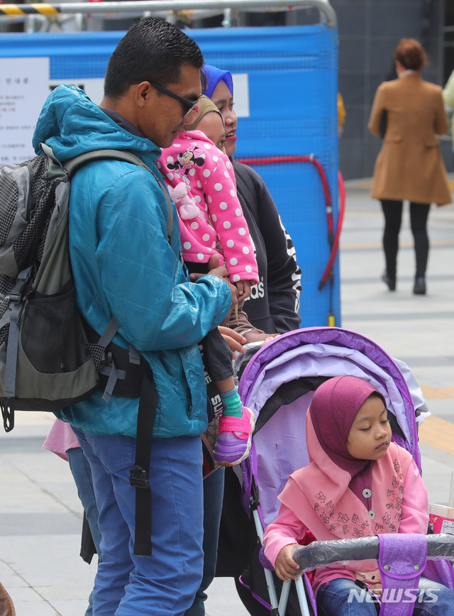【서울=뉴시스】배훈식 기자 = 강한 바람이 불며 다소 쌀쌀한 날씨를 보인 지난 18일 오후 서울 종로구 세종문화회관 앞에서 한 외국인 가족이 외투를 걸치고 차량 전시회를 보고 있다. 2019.04.18. dahora83@newsis.com