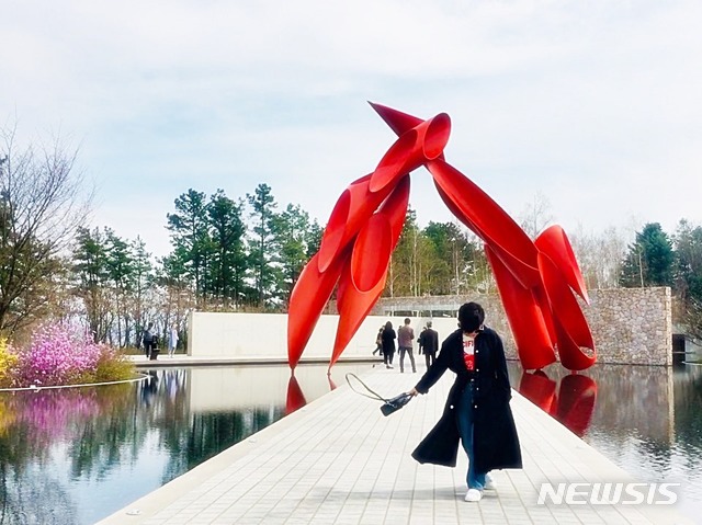 【서울=뉴시스】박현주 미술전문 기자 =뮤지엄산 갤러리로 들어가는 '워터 가든'은 사진 찍는 장소로 유명하다. 뮤지엄 본관이 물 위에 떠 있는 거처럼 느껴지는 고유하고 눈부신 물의 정원은 거대한 빨강색 조형물이 압권이다. 알렉산더 리버만(Alexander Liberman) 아치웨이(Archway) 작품으로 뮤지엄 산의 랜드마크가 됐다.