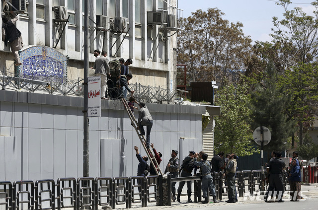 【카불(아프가니스탄)=AP/뉴시스】20일(현지시간) 아프가니스탄 카불 정보통신부 건물이 무장 괴한의 습격을 받은 가운데 치안 병력이 건물에서 사람들을 대피시키고 있다.&nbsp; 나스라트 라히미 내무부 대변인은 "3명의 무장 괴한이 치안 병력과 교전을 벌여 적어도 두 명이 사살됐다"라고 밝혔다. 2019.04.20.