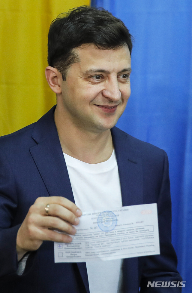 【키에프=AP/뉴시스】 우크라이나 대통령선거 결선투표가 치러진 21일(현지시간) 코미디언 겸 배우 볼로디미르 젤렌스키가 투표소에서 투함 전 투표지를 들어보이고 있다. 2019.04.22.