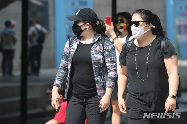 【서울=뉴시스】박미소 수습기자 = 초여름 날씨를 보이는 22일 오전 서울 중구 청계천에서 미세먼지 마스크를 쓴 외국인 관광객들이 반팔을 입고 발걸음을 옮기고 있다. 2019.04.22. misocamera@newsis.com