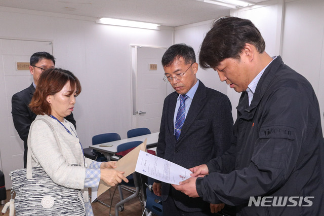 【서울=뉴시스】박미소 수습기자 = 지난 4월22일 오후 서울 용산구 한국유치원총연합회 사무실에서 이정숙 서울시교육청 주무관(왼쪽)이 김철 한유총 사무국장에게 한유총 법인 설립허가 취소 통보서를 전달하고 있다.2019.04.22. photo@newsis.com