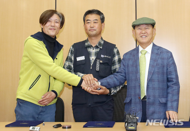 【서울=뉴시스】김병문 수습기자 = 콜텍 노사가 2007년 정리해고 사태 이후 12년 만에 해고자 복직에 잠정 합의한 가운데 이인근(왼쪽부터) 금속노조 콜텍지회장, 김호규 금속노조 위원장, 박영호 콜텍 사장이 23일 오전 서울 강서구 서울가스공사 서울지역본부에서 열린 조인식에 참석해 합의안에 서명 후 기념촬영하고 있다. 콜텍투쟁 승리를 위한 공동대책위에 따르면 복직자들은 내달 2일 복직해 30일까지 근무한 뒤 퇴직하며 처우는 부속 합의서에 따르기로 했다고 밝혔다. 2019.04.23.&nbsp; dadazon@newsis.com