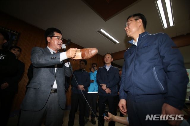 【고성(강원)=뉴시스】김경목 기자 = 강원도 고성.속초 대형산불 피해 이재민이 24일 오전 강원도 고성군 토성면 행정복지센터(면사무소) 재난안전대책본부 브리핑 공간에서 지난 4~5일 발생한 고성·속초 대형산불의 발화 원인으로 한전의 전신주 등 시설물이라는 사실이 국립과학수사연구원의 감정 결과 드러난 것과 관련해 한전의 설명회가 열린 자리에서 김종갑 사장 앞에서 신발을 벗어 손에 들고 이재민들의 분노한 심경을 말하고 있다. 2019.04.24. photo31@newsis.com