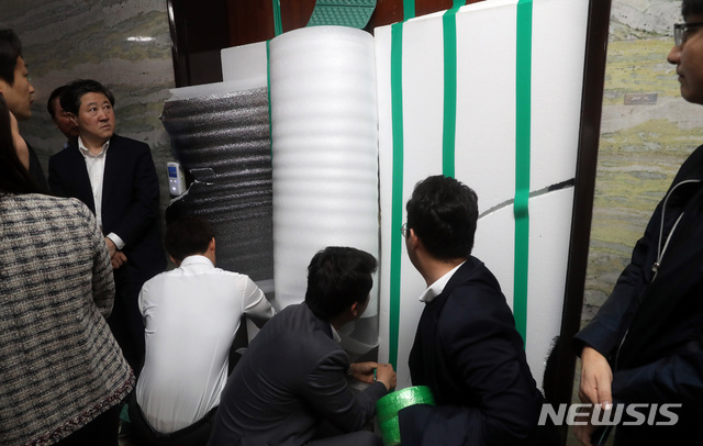 【서울=뉴시스】 박영태 기자 = 선거제 개편안과 사법제도 개혁안의 패스트트랙 지정을 반대하는 자유한국당 의원들과 당직자들이 26일 오전 서울 영등포구 여의도 국회 본청 의안과의 파손된 문을 스티로폼으로 가리고 있다. 2019.04.26. since1999@newsis.com