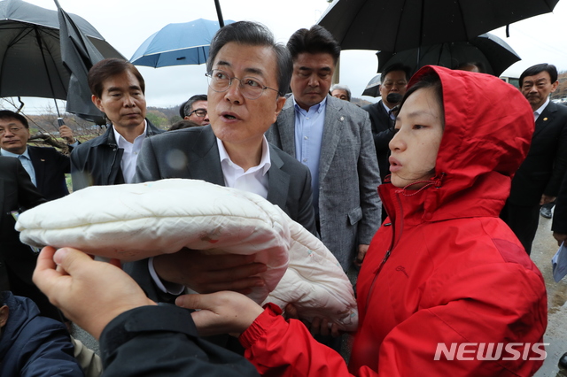 【고성(강원)=뉴시스】박진희 기자 = 문재인 대통령이 26일 강원도 고성군 토성면 성천리 마을 산불피해 복구현장을 방문해 베트남이주여성의 아기를 안아주고있다. 2019.04.26.&nbsp; pak7130@newsis.com 