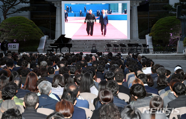 【판문점=뉴시스】사진공동취재단 = 4.27 판문점 선언 1주년 기념식이 열린 27일 오후 경기 파주시 판문점 평화의 집 앞에서 참석자들이 판문점 선언 관련 영상을 시청하고 있다. 2019.04.28.&nbsp;&nbsp; photo@newsis.com