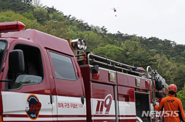 【서울=뉴시스】김병문 수습기자 = 29일 오후 서울 성북구 북한산 일대에서 도심산불에 특화된 산불진화 장비 활용 훈련이 진행되고 있다. 소방재난본부는 이 날 도심산불 대비 유관기관 합동 산불진화 훈련에서 소방항공대 헬기투입 공중방수와 소방호스와 이동식 엔진(가반식)펌프를 직결한 고압방수 훈련을 실시했다.  2019.04.29.  photo@newsis.com