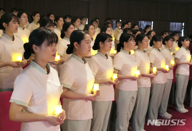 [청주=뉴시스] 인진연 기자 = 2일 충북대학교 대학본부 대강연실에서 열린 '6회 나이팅게일 선서식'에서 간호학과 3학년에 재학 중인 예비간호사들이 촛불의식을 하고 있다. 2019.05.02 (사진=충북대 제공)photo@newsis.com