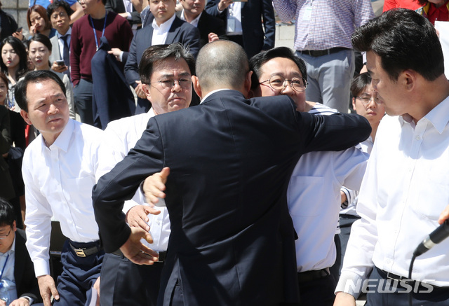 【서울=뉴시스】이종철 기자 = 자유한국당 김태흠 좌파독재저지특위 위원장을 비롯해 윤영석·이장우·성일종 의원과 이창수 충남도당 위원장이 2일 오전 국회 본관 앞 계단에서 선거법 개정안과 공수처 법안 패스트트랙 지정의 부당성을 알리는 삭발식을 했다. 먼저 삭발한 박대출 의원(뒷모습)이 삭발을 앞둔 의원들과 포옹하고 있다. 왼쪽부터 성일종 의원, 김태흠 위원장, 박대출 의원, 이장우 의원, 윤영석 의원. 2019.05.02.&nbsp; jc4321@newsis.com