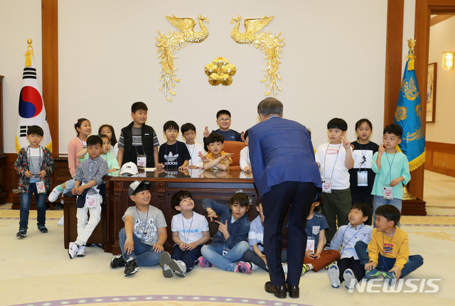 【서울=뉴시스】박진희 기자 = 문재인 대통령이 5일 청와대 본관 집무실에서 제97회 어린이날 청와대 초청행사에 참석한 어린이들과 기념촬영에 앞서 집무실을 소개하고 있다. 2019.05.05.&nbsp; pak7130@newsis.com
