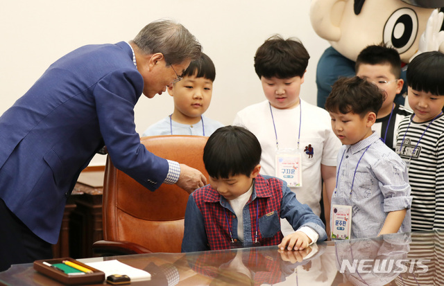 【서울=뉴시스】박진희 기자 = 문재인 대통령이 5일 청와대 본관 집무실에서 제97회 어린이날 청와대 초청행사에 참석한 어린이들을 대통령 집무실 의자에 앉히고 있다. 2019.05.05.&nbsp; pak7130@newsis.com