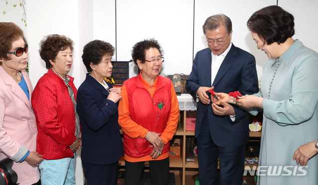 【서울=뉴시스】박진희 기자 = 문재인 대통령과 부인 김정숙 여사가 어버이날을 하루 앞둔 7일 서울 금천구 치매안심센터에서 손수 만든 종이 카네이션을 어르신들께 달아 드리고 있다. 2019.05.07.&nbsp; pak7130@newsis.com