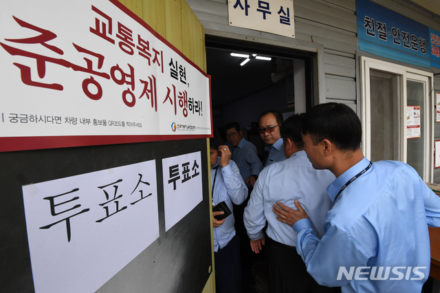 【수원=뉴시스】김종택 기자= 8일 주 52시간 근로시간제 도입에 따른 임금 조정 문제를 놓고 노사 간 협상이 난항을 겪고 있는 경기지역 광역버스 노동조합이 파업 찬반 투표에 들어간 가운데 경기 용인시 처인구 한 버스업체 노조원들이 투표를 하기 위해 투표소로 들어가고 있다. 2019.05.08semail3778@naver.com