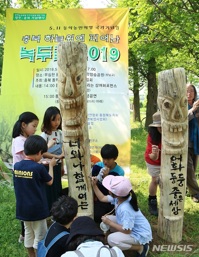 【청주=뉴시스】강신욱 기자 = 11일 충북 청주시 서원구 모충동 청남교 남쪽 동학장승공원에서 열린 동학농민혁명 국가기념일 제정 기념행사에서 어린이들이 장승에 색으로 옷을 입히고 있다. 2019.05.11. ksw64@newsis.com 