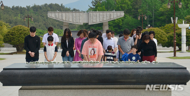 【광주=뉴시스】변재훈 기자 = 5·18민주화운동 39주년 기념식을 일주일 앞둔 12일 광주 북구 운정동 국립 5·18민주묘지에 참배객들의 발걸음이 이어지고 있는 가운데 한 일가족이 추모탑 앞에서 오월영령 앞에 묵념하고 있다. 2019.05.12.   wisdom21@newsis.com