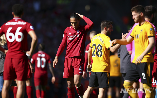Liverpool's Virgil van Dijk, center, reacts at the end of the English Premier League soccer match between Liverpool and Wolverhampton Wanderers at the Anfield stadium in Liverpool, England, Sunday, May 12, 2019. Despite a 2-0 win over Wolverhampton Wanderers, Liverpool missed out on becoming English champion for the first time since 1990 because title rival Manchester City beat Brighton 4-1. (AP Photo/Dave Thompson)