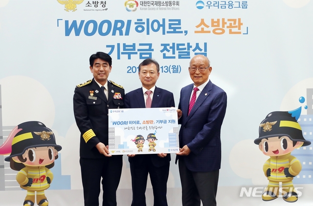 【서울=뉴시스】우리금융그룹은 소방관과 그 가족을 위해 ‘우리 히어로, 소방관 지원사업’을 실시하기로 하고, 지난 13일 서울 중구 본점에서 기부금 전달식을 가졌다. 사진은 조수형 우리은행 소비자브랜드그룹장(사진 가운데)와 최병일 소방청 소방정책국장(사진 왼쪽), 오세억 대한민국재향소방동우회 회장. 