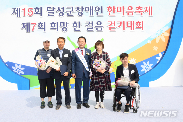 【대구=뉴시스】 강병서 기자=대구 달성군민운동장에서 14일 열린 제15회 달성군 장애인 한마음축제 및 제7회 희망 한걸음 걷기대회에서 장애인 복지증진에 힘쓴 군민 4명이 김문오 달성군수(중앙)로부터 표창을 받았다. 2019.05.14. (사진=달성군 제공) photo@newsis.com