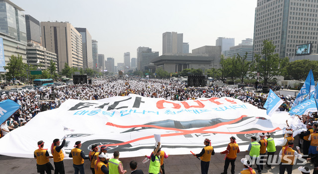 【서울=뉴시스】박미소 기자 = 15일 오후 서울 종로구 광화문 광장에서 개인택시운송사업조합 주최로 열린 '타다 퇴출 요구 집회'에서 참석자들이 '타다 OUT' 현수막 퍼포먼스를 하고 있다. 2019.05.15.&nbsp; misocamera@newsis.com