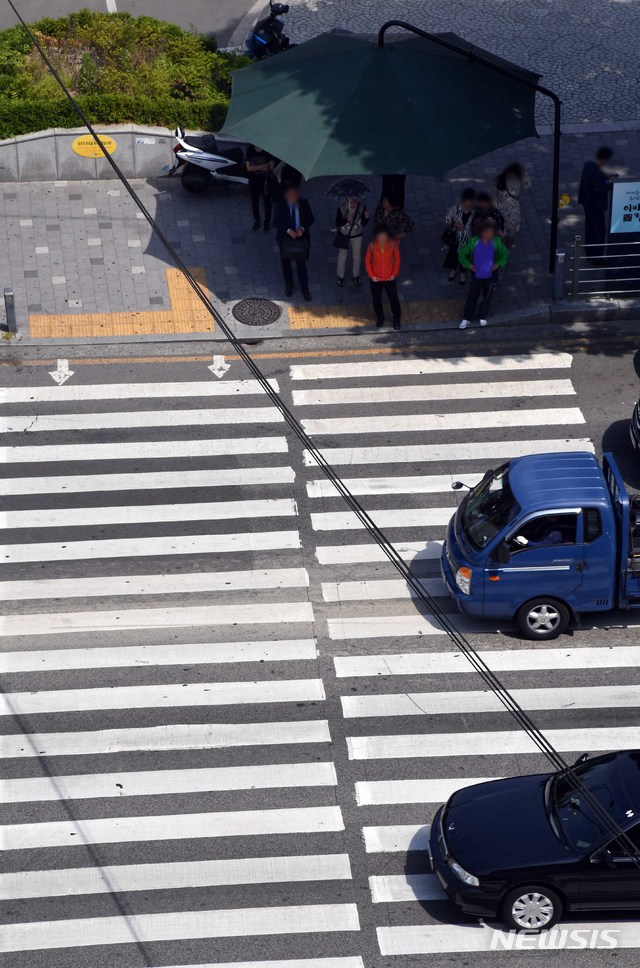 【부산=뉴시스】 하경민 기자 = 부산 일부 지역 낮 최고기온이 27도를 웃도는 초여름 날씨를 보인 15일 오후 동구 부산역 앞 횡단보도에서 시민과 관광객들이 그늘막 아래서 강하게 내리쬐는 햇볕을 피하고 있다.부산시 전역에는 2017년부터 올해까지 총 334개(5월 15일 기준)의 그늘막이 설치됐다. 2019.05.15. yulnetphoto@newsis.com