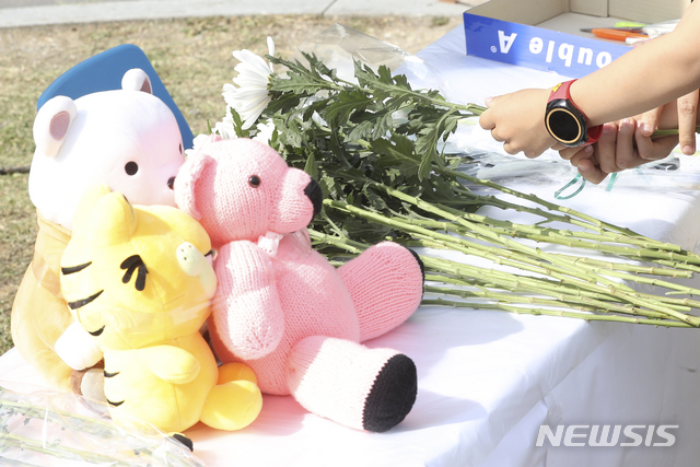 【인천=뉴시스】최진석 기자 = 16일 오후 인천시 연수구 송도국제신도시 축구클럽 차량 사고 현장 앞 희생자 추모 공간을 찾은 어린이가 헌화하고 있다. 지난 15일 발생한 이 사고로 축구클럽 차량에 탑승했던 초등학생 2명이 숨지는 등 8명의 사상자가 발생했다. 2019.05.16.myjs@newsis.com