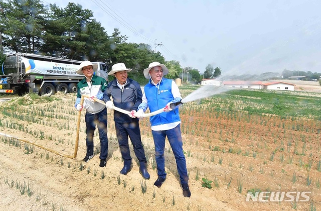 【서울=뉴시스】오비맥주는 자사 생산공장이 위치한 경기도 이천지역의 가뭄 피해 농가를 돕기 위해 지원한다고 17일 밝혔다.이날 오비맥주가 생산공장이 위치한 이천시 대월면 사동리 농가에서 맥주 생산에 사용하는 용수를 메마른 밭에 공급하고 있다. 2019.5.17(사진=오비맥주 제공) photo@newsis.com