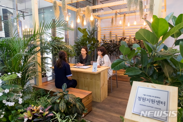【서울=뉴시스】 해누리타운1층로비에 설치된 정원지원센터에서 상담 중인 모습. 2019.05.17. (사진=양천구 제공)