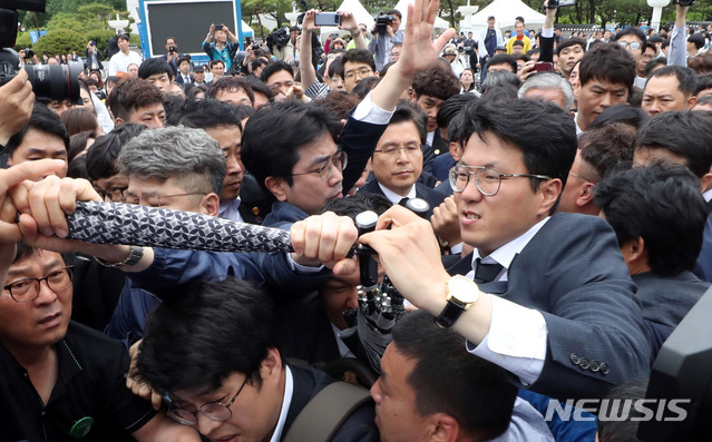 【광주=뉴시스】 박영태 기자 = 자유한국당 황교안 대표가 18일 오전 제39주년 5.18민주화운동 기념식이 열린 광주광역시 북구 국립 5.18 민주 묘지에서 추모탑에 분향을 하려다 5.18유가족과 시민단체의 반대로 항의로 분향을 못하고 기념식장을 빠져나가고 있다. 2019.05.18.&nbsp; since1999@newsis.com