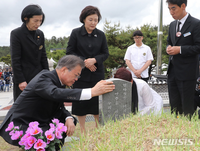 【광주=뉴시스】박진희 기자 = 문재인 대통령과 부인 김정숙 여사가 18일 오전 광주 북구 국립5·18민주묘지에서 열린 '제39주년 5·18민주화운동 기념식'을 마치고 5·18희생자 고 김완봉 묘역을 찾아 참배하고 있다. 고 김완봉(66년 7월 24일부터 80년 5월 21일)씨는 친구와 절을 간다며 길을 나셨다가 사망했고, 어머니는 적십자병원에서 아들 시체를 찾았고 29일까지 아들을 지키다가 묘역에 안장했다. 2019.05.18.  pak7130@newsis.com